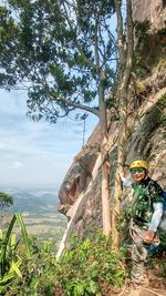 Man climbing on tree trunk