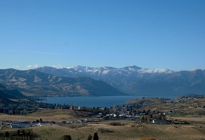 Scenic view of lake chelan and mountains against clear blue sky