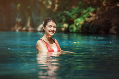 Portrait of young woman swimming in lake