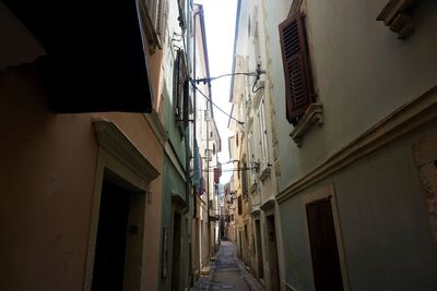 Low angle view of narrow alley amidst buildings