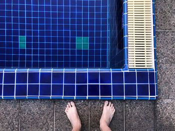 Low section of man standing at poolside