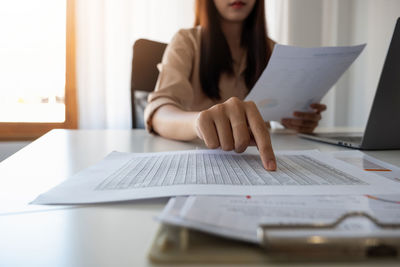 Midsection of businesswoman analyzing at office