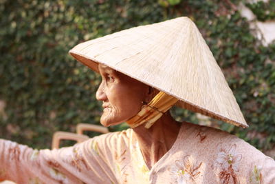 Close-up of senior woman wearing asian style conical hat