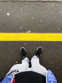 Low section of man standing on road