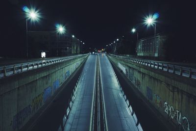 Railroad tracks in city at night