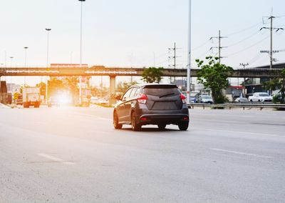 Car on road in city against sky