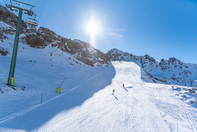 People skiing on snowcapped mountain against sky