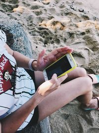 High angle view of woman using mobile phone at beach