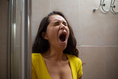 Portrait of young woman standing in bathroom