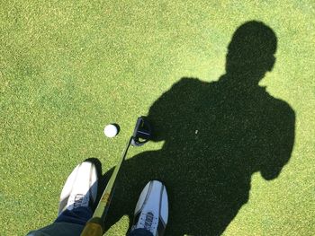 Low section of man standing at golf course