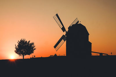 Silhouette traditional windmill against sky during sunset
