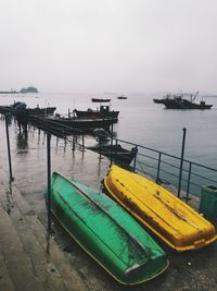 Upside down boats moored on pier by sea