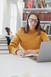 Portrait of woman using laptop at table