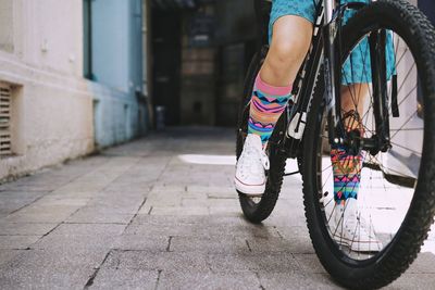 Low section of girl riding bicycle on street