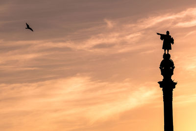 Low angle view of silhouette statue against sky during sunset