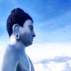 Close-up portrait of statue against blue sky