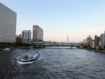 River by buildings against sky in city