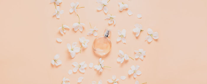 Directly above shot of perfume bottle amidst pink flowers