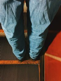 Low section of man standing on escalator