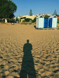 Shadow of man on sand at beach against clear sky