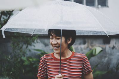 Portrait of happy young woman in rain