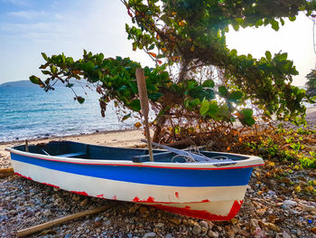 Boat moored on shore against sky