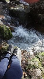 Low section of man standing on rock