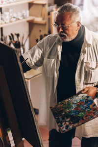 Man painting on canvas at workshop