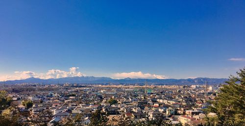 Aerial view of town against blue sky