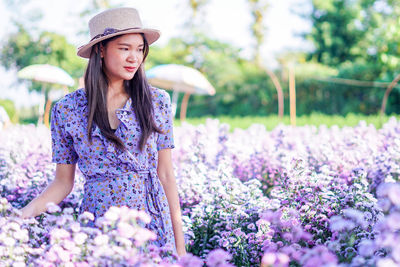 Full length of woman standing by flowering plants