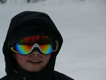 Close-up of child on snow covered field