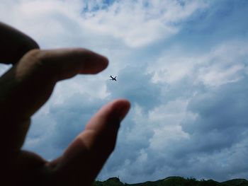 Cropped image of person holding hands against sky