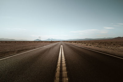 Empty road along countryside landscape