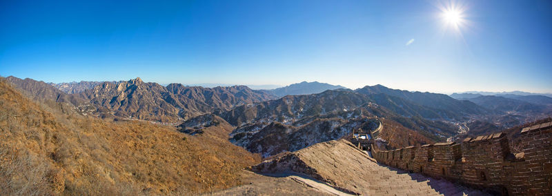 Panoramic view of mountain range against blue sky