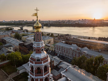 Aerial view of buildings in city at sunset