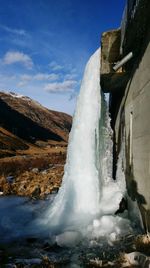 Low angle view of waterfall against sky