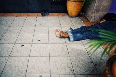 Low section of man eating food on tiled floor