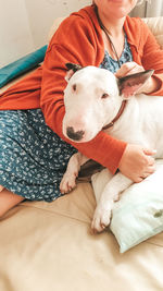 Midsection of woman sitting with dog