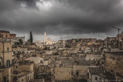 Houses and buildings against cloudy sky