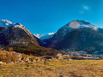 Scenic view of snowcapped mountains against blue sky