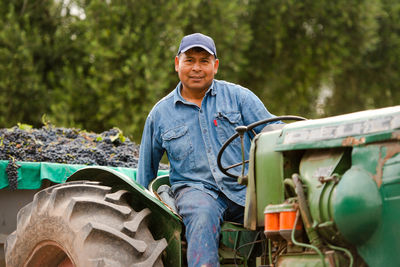 Portrait of man sitting on tractor in farm