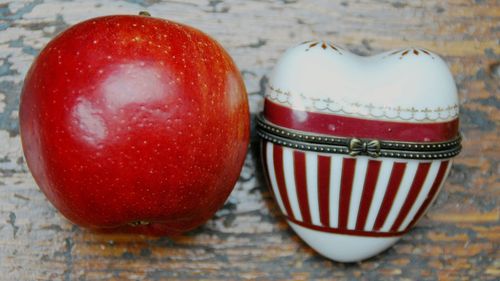 Directly above view of apple and heart shape porcelain on table