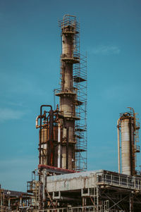 Low angle view of oil industry against sky