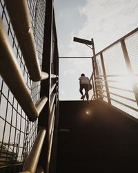 Low angle view of man on staircase against sky