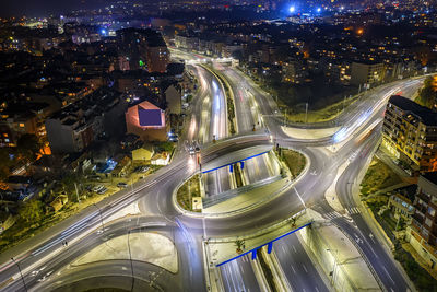 High angle view of illuminated street amidst buildings in the city at night