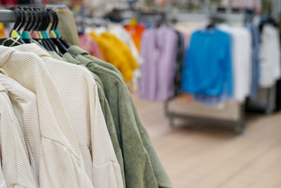 Men's clothes on hangers in a retail shop. fashion and shopping concept