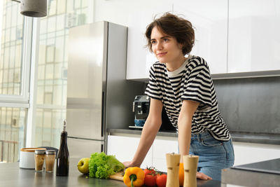 Portrait of young woman preparing food at home