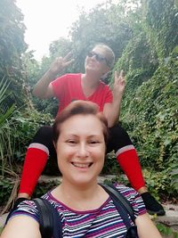 Portrait of happy smiling woman against plants