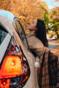 Side view of young woman in car