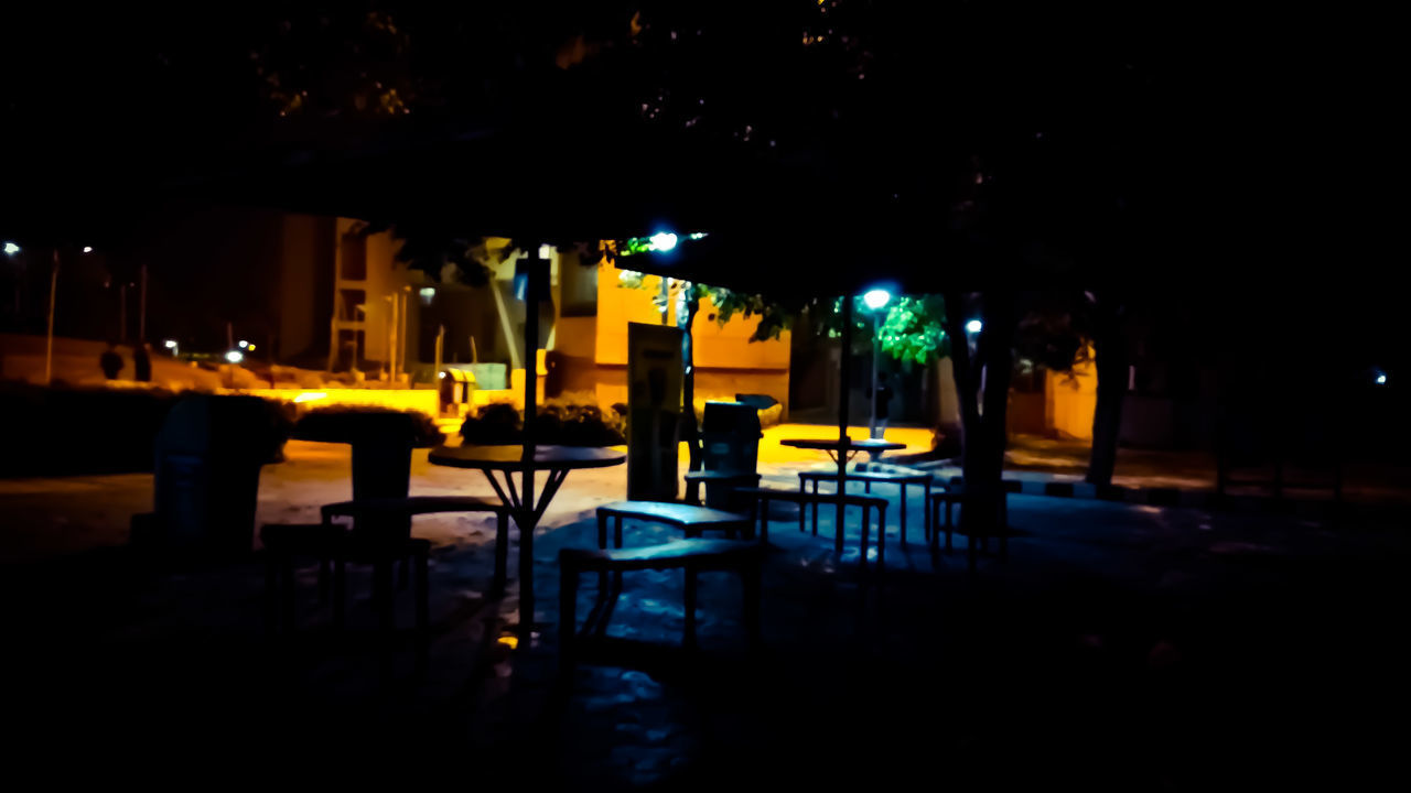 ILLUMINATED TABLES AND CHAIRS AT NIGHT